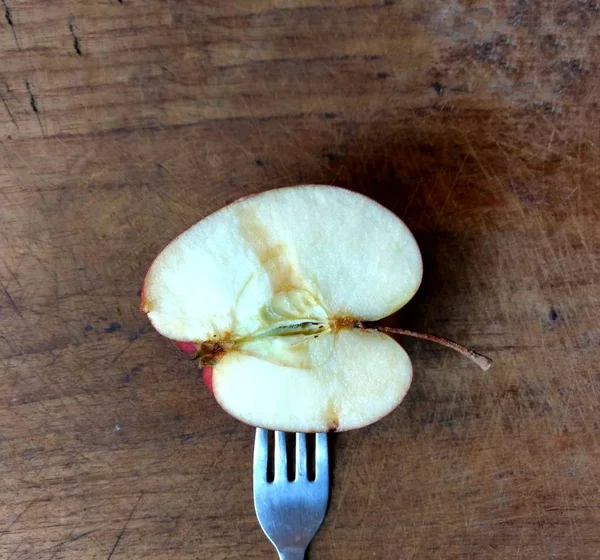 Garfo com uma fatia de maçã em uma tábua de madeira. conceito de alimentação saudável — Fotografia de Stock