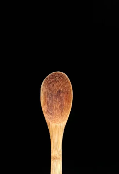 Wooden spoon on black background — Stock Photo, Image