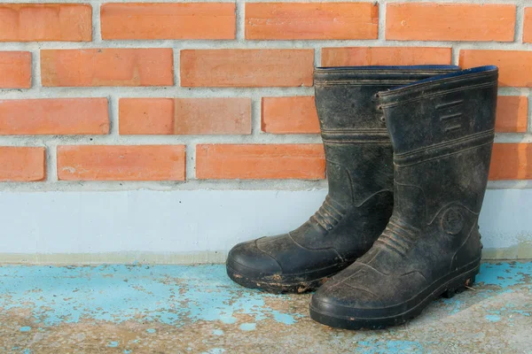 kırmızı tuğlalı duvarda bahçe ayakkabıları