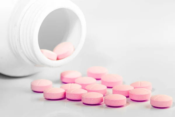 İlaç şişesinden beyaz arka plana dökülmüş.