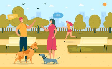 Erkek ve kadın köpekleriyle parkta yürüyorlar..