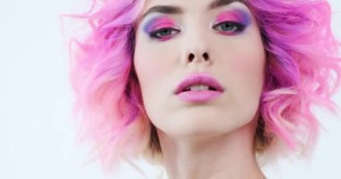 Parlak mor saçlı bir mankenin yakın plan portresi. Moda tarzı olan şık bir kadın. Pembe makyajlı güzel bir yüz. Modaya uygun bir kız. Sanat konsepti. 4K görüntü. Gerçek zamanlı..