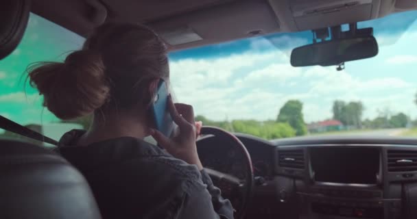 女は車を運転する 車の中で幸せな女性が電話で話している 美しい大人の笑顔の女性が車を運転している 自動車を運転している間に白い大人の女の子が携帯電話で話します リアルタイムだ中へ — ストック動画