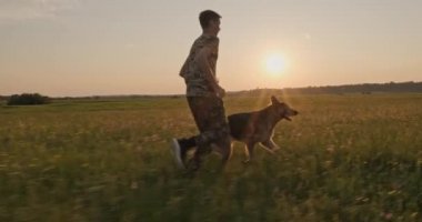 Günbatımında genç bir köpek ile doğada koşuyor. 15 yaşında bir çocuk bir Alman çoban köpeğiyle koşuyor. Sahada köpekli bir genç. Beyaz adam çayırda evcil hayvanıyla oynuyor. Yavaş çekim