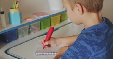 Çocuk numaraları okul defterine yazıyor. Öğrenci çocuk evde matematik ödevi yapıyor. Rakamları okul çocuğu yazıyor. Çocuk okuldan sonra ev ödevi yapar. Gerçek zamanlı. 4k görüntü    