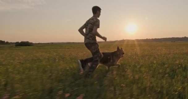 Adolescente Está Corriendo Con Perro Naturaleza Mientras Pone Sol Niño — Vídeo de stock