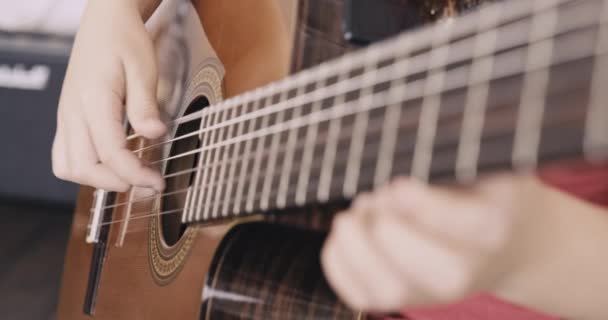给孩子们的手弹奏吉他 一个拿着吉他的小男孩 8岁的男孩弹古典吉他 这个高加索小孩学会了弹吉他 自然光 — 图库视频影像
