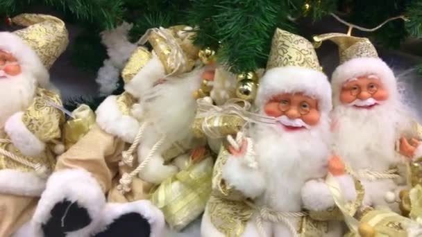 玩具圣诞老人 圣诞玩具圣诞老人 身穿金色衣服的玩具圣诞老人坐在树下 潘沿着玩具圣诞老人 4K视频 圣诞装饰品 新年装饰 2020年 — 图库视频影像