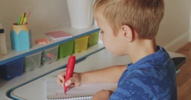 Çocuk numaraları okul defterine yazıyor. Öğrenci çocuk evde matematik ödevi yapıyor. Rakamları okul çocuğu yazıyor. Çocuk okuldan sonra ev ödevi yapar. Gerçek zamanlı. 4k görüntü    