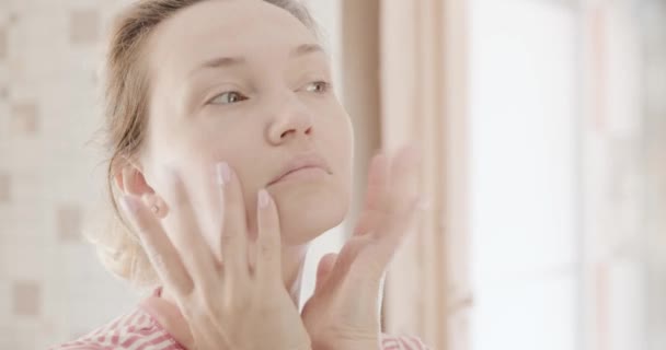 做面部按摩的成年妇女 美丽的女人做抗衰老的面部按摩 35岁的白人妇女正在照顾皮肤 美容疗法 身体疗法 肌肤健康晨间护理程序 — 图库视频影像