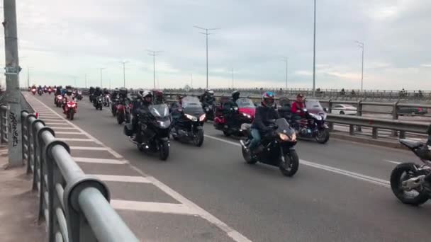 オートバイの大規模な船団は 市内に乗る 近代的なオートバイのバイカーが街の高速道路に沿って移動します 巨大なオートバイのグループが道路に乗っています 自動二輪車の音 — ストック動画