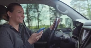 Kadın arabada kaza geçirir. Yolda tehlikeli bir durum var. Kadın arabayı sürüyor ve akıllı telefondan mesaj yazıyor. Araba kullanırken cep telefonu kullanan yetişkin bir kadın. Gerçek zamanlı.. 