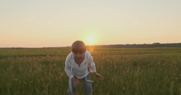 Щаслива Дитина Піднятими Руками Стрибає Під Час Заходу Сонця Влітку — стокове відео