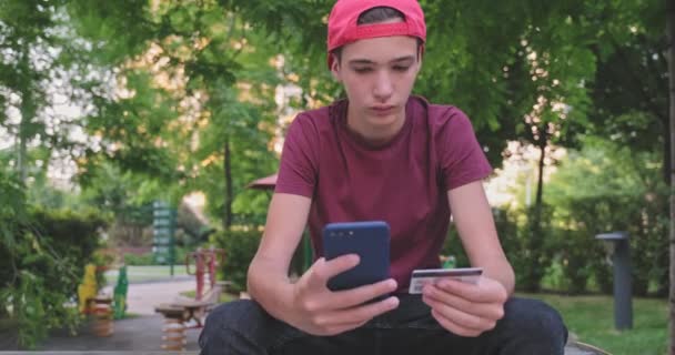 Подросток Делает Онлайн Покупки Помощью Кредитной Карты Мобильного Телефона Улыбающийся — стоковое видео