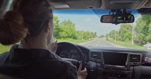 女は車を運転する 美しい大人の笑顔の女性が車を運転している 幸せな大人の女の子の車を運転 白人女性への眺めの中で車を運転します リアルタイム — ストック動画