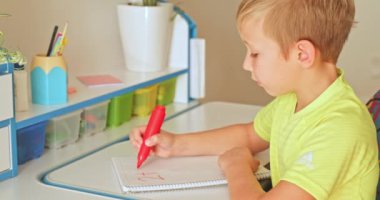 Çocuk numaraları okul defterine yazıyor. Öğrenci çocuk evde matematik ödevi yapıyor. Rakamları okul çocuğu yazıyor. Çocuk okuldan sonra ev ödevi yapar. Gerçek zamanlı. 4k görüntü    