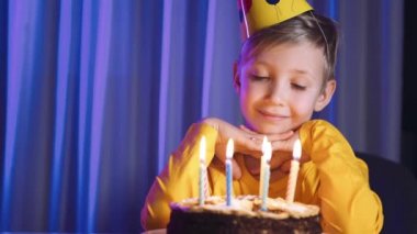 Mutlu çocuk mumlu pastaya bakar ve bir dilek tutar. Tatlı çocuk doğum gününde pastaya mum üflüyor. Çocuk pastaya bakar ve doğum günü dileği diler. Çocuk doğum gününü kutluyor..