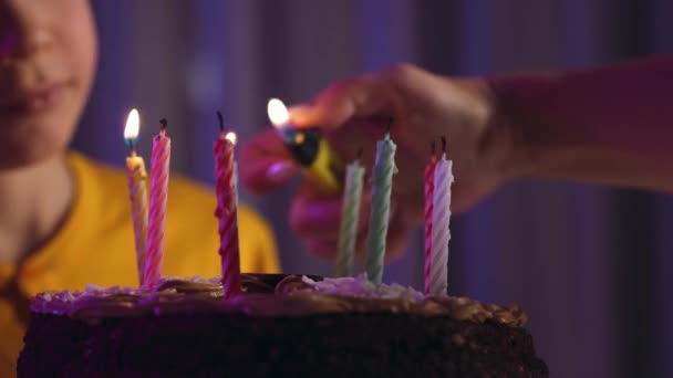 ママは息子の誕生日ケーキにろうそくを灯す 子供は母親が誕生日にろうそくを灯すのを見る ろうそくの閉まりと誕生日ケーキ 照明休日のろうそく — ストック動画