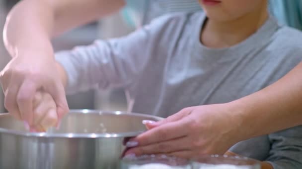 慢动作4K镜头 母子搅拌钢碗中的面团 妈妈在厨房做饭的男孩家里做饭的家庭 妈妈和儿子混合烘焙饼干的配料 — 图库视频影像