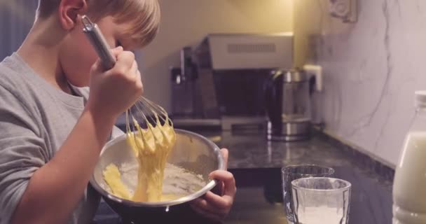 孩子们用铁碗里的威士忌搅拌着煎饼混合物 8岁的男孩在厨房里做饭 男孩把面粉混合在一起做饼干 吃饭时间 童年的概念 — 图库视频影像