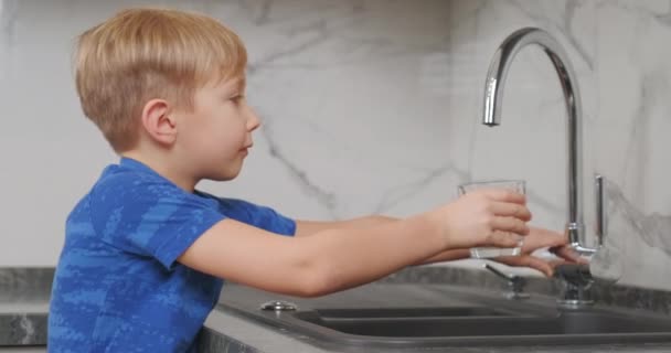 Dziecko Bierze Przezroczystą Szklankę Napełnia Świeżą Wodą Pije Blondyn Idzie — Wideo stockowe