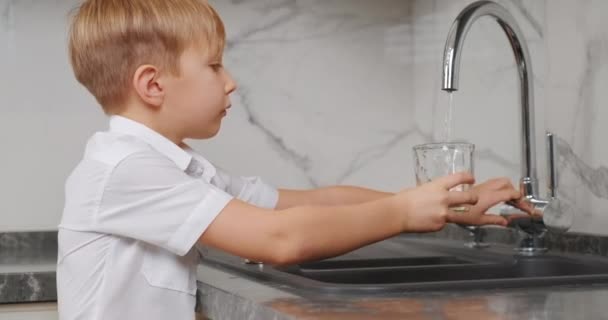 Bambino Prende Bicchiere Trasparente Riempie Acqua Dolce Beve Ragazzo Biondo — Video Stock