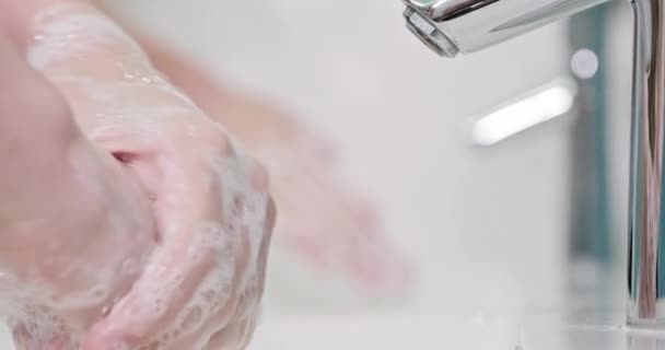 スローモーション 2人のシンクで手洗浄ゲルで彼の手を洗っている コロナウイルスのパンデミック予防は 水で暖かい石鹸で手を洗う 石鹸で手を丁寧に洗う二人 — ストック動画