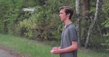 Çocuk uzaktan kumandayı kullanarak dronu kaldırıyor. Ergen, açık havada insansız hava aracı fırlatıyor. Genç adam doğada bir kuadrokopterle oynuyor. Beyaz çocuk parkta İHA uçurmayı öğreniyor..  