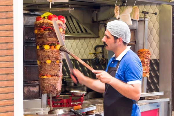 Bir adam sokakta et pişiriyor..