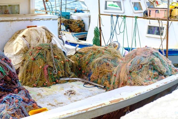 Redes de pesca multicolores plegadas en la cubierta de un barco de pesca . —  Fotos de Stock