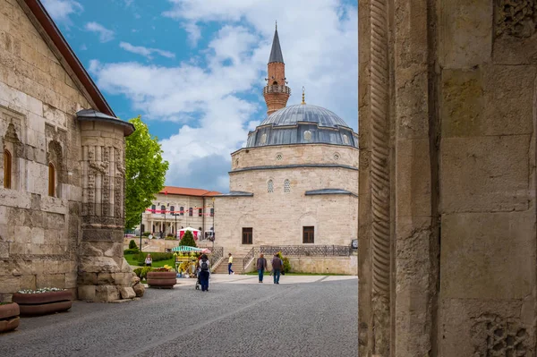Camiye ve kervana bakan şehir meydanı..