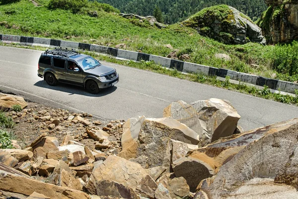 汽车在岩石上行驶，部分堵塞了山路. — 图库照片