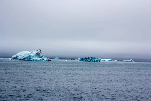 Viejo iceberg pintado con microorganismos en azul, el Ártico . — Foto de Stock