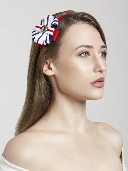 Ελκυστικό το όμορφο μοντέλο μελαχρινή κοπέλα με μπλε, λευκό και κόκκινο barrette απομονωθεί σε λευκό. — Φωτογραφία Αρχείου