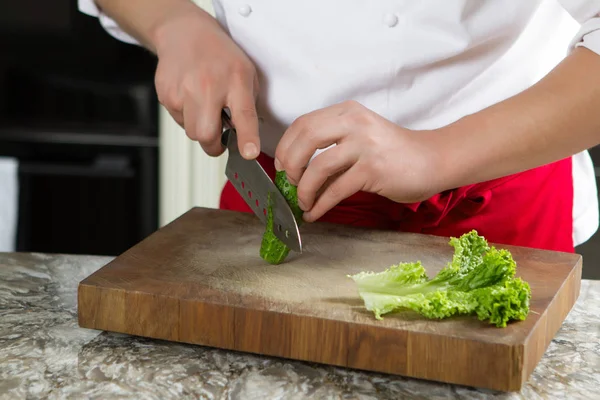 Chef-kok snij de komkommer met het grote mes in de keuken — Stockfoto