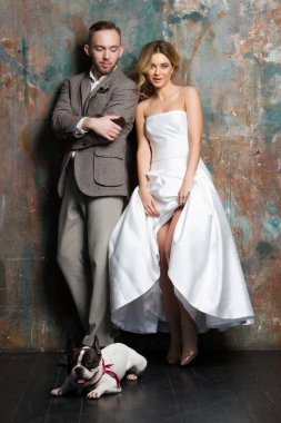 Genç gelin ve damat ile birlikte köpek yerde duran