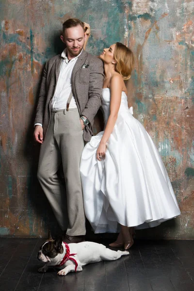 Genç gelin ve damat ile birlikte köpek yerde duran