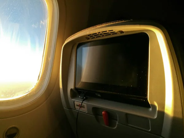 Personliga underhållande skärm på flygplan säte på morgonen — Stockfoto