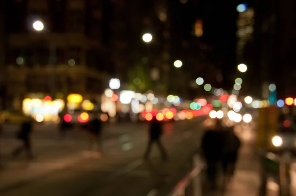 Desfocado fundo abstrato de pessoas caminhando à noite em ocupado — Fotografia de Stock