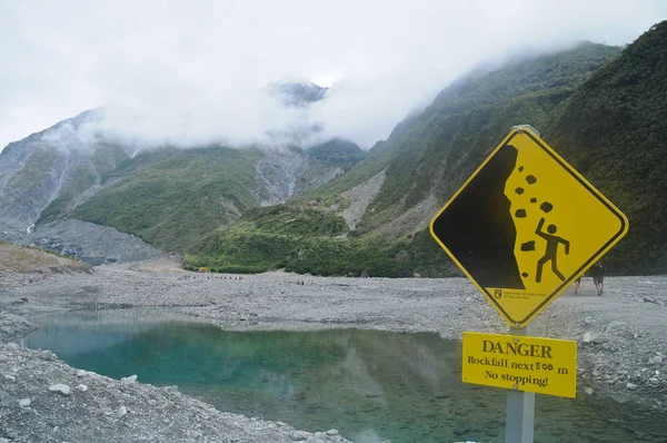 ニュージーランドの湖で落石に注意の警告看板 — ストック写真