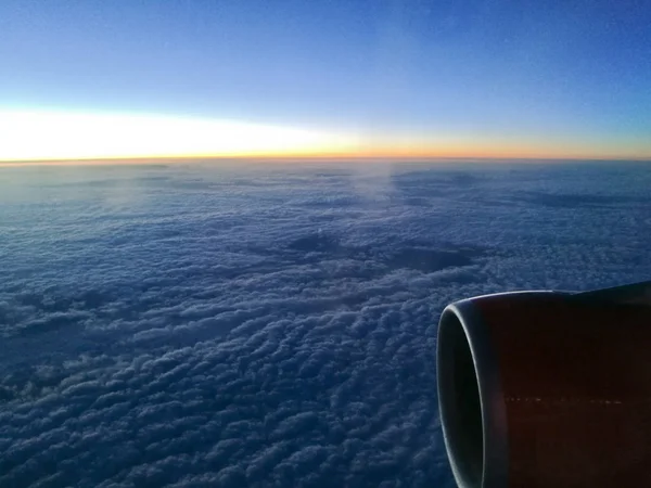 Солнце встает над облаком из окна самолета — стоковое фото