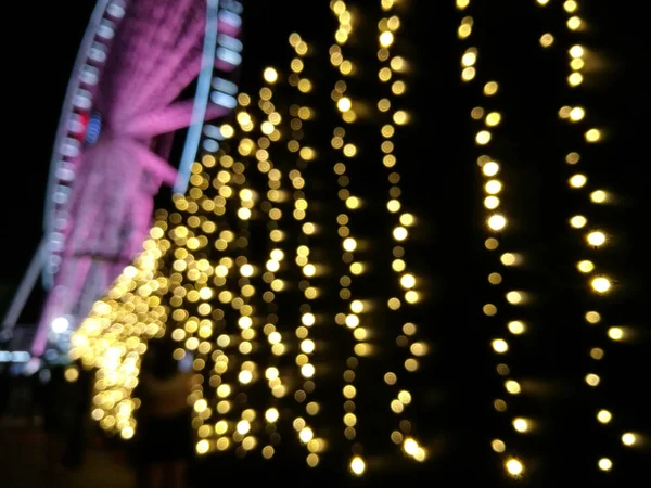 Escena desenfocada de volante gigante rosa ferris rueda en la noche con y — Foto de Stock