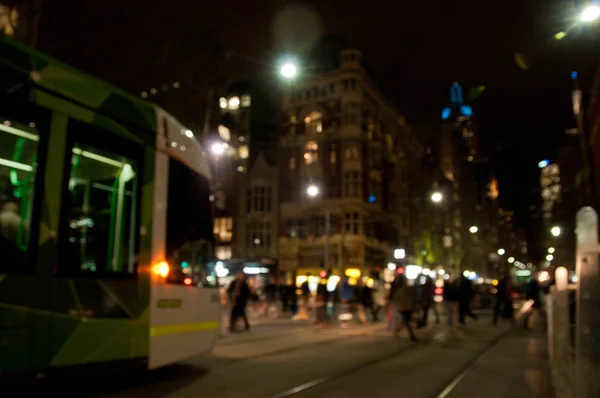 Intreepupil scène van mensen lopen met tram's nachts in drukke cit — Stockfoto