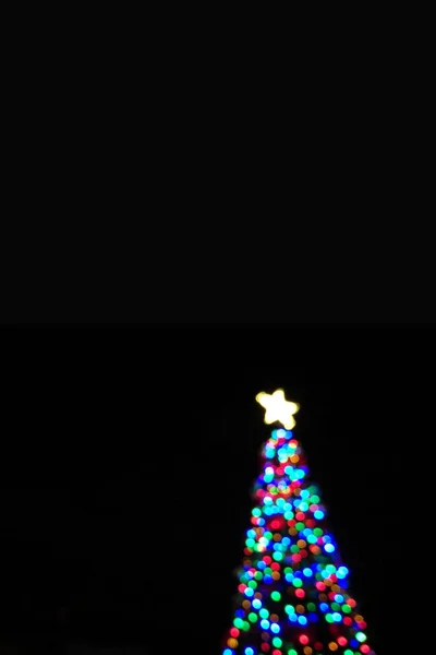 A Defocused elvont fény ünnepel Karácsony Christmas tree alakzat függőleges fekete-kártya — Stock Fotó