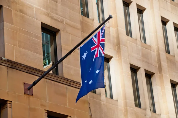 Flag of Australia hang from a sandstone building