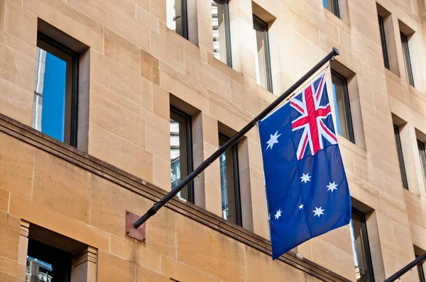 Flag of Australia hang from a sandstone building