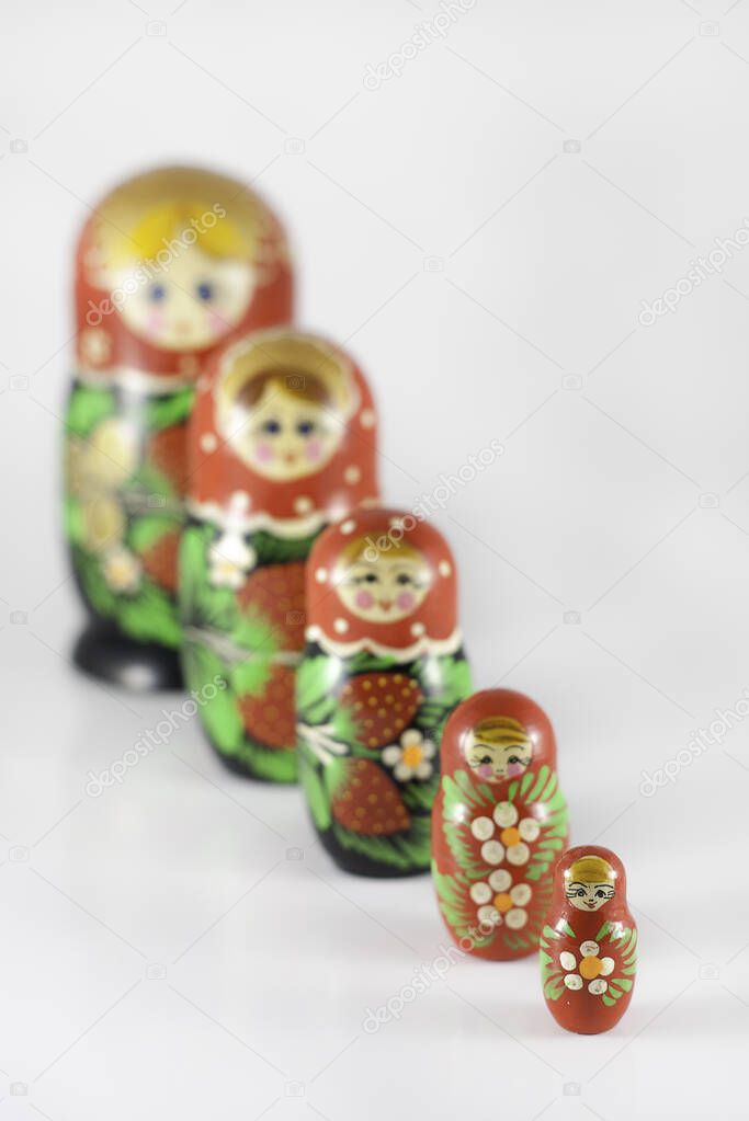 Matryoshka dolls ordered from large to small, with the focus on the small doll in front