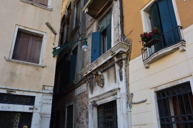 Venedik (İtalya) Haziran 2019. Şehrin dar sokaklarından biri. İki kişi cadde boyunca zar zor dağıldı..