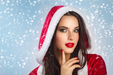 Noel Santa şapka kadın portre Noel hediyesi tutun. Mavi arka plan üzerinde gülümseyen kız mutlu. Noel Baba elbise giyen güzel seksi kız portresi.