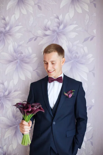 Herrlich lächelnder Bräutigam. andsome Bräutigam bei der Hochzeit Smoking lächelnd und wartet auf Braut. Eleganter Mann in schwarzem Kostüm und Fliege. — Stockfoto